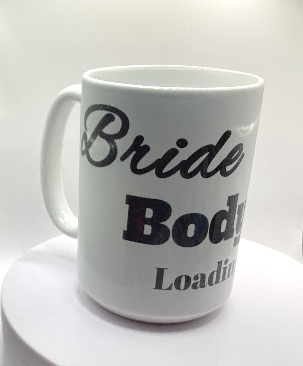 This “Bride Body Loading” mug is a white ceramic mug designed to celebrate a bride’s fitness journey as she prepares for her wedding. The mug features the phrase “Bride Body Loading” and a picture of a ring.
