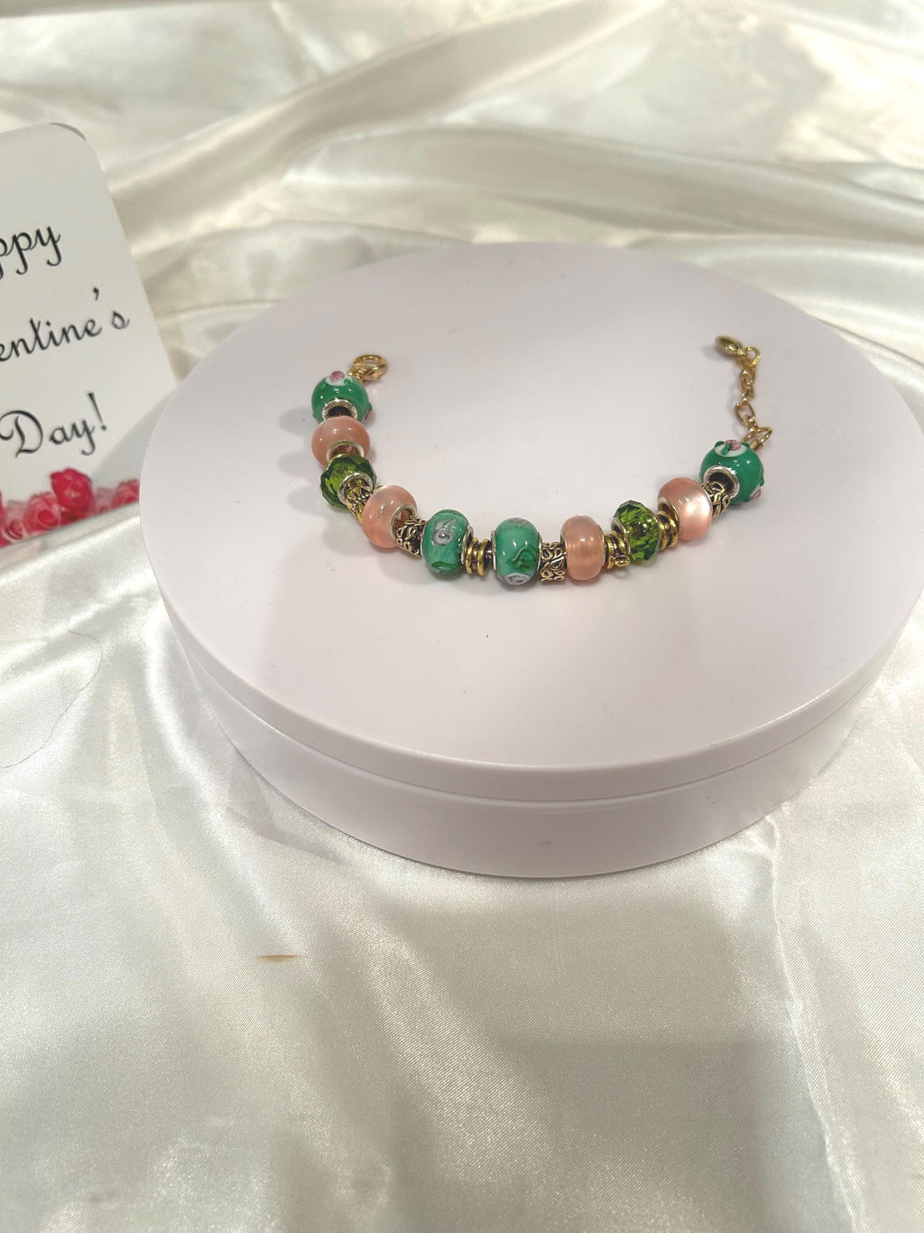 Green, pink and gold-beaded bracelet.