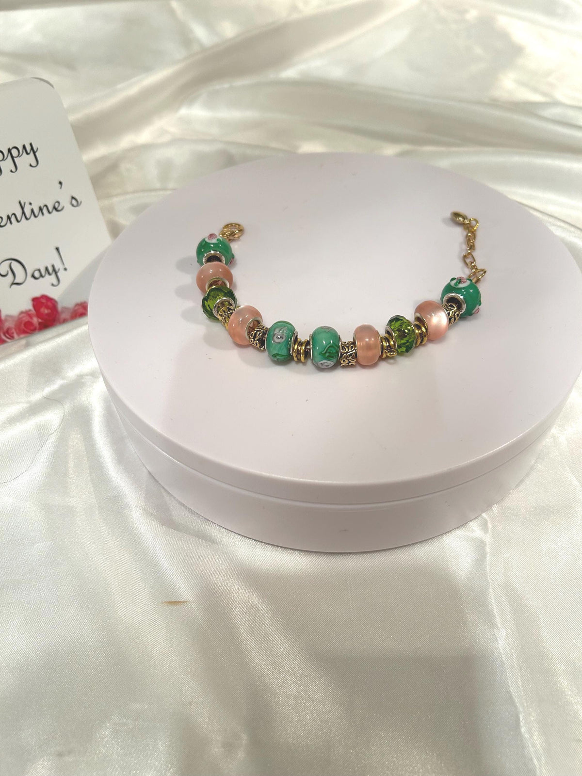 Green, pink and gold-beaded bracelet.