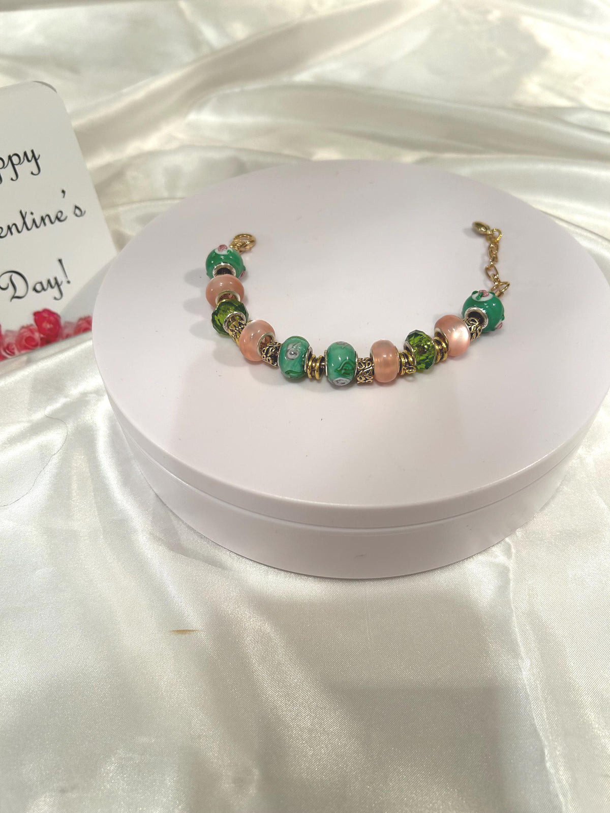 Green, pink and gold-beaded bracelet.